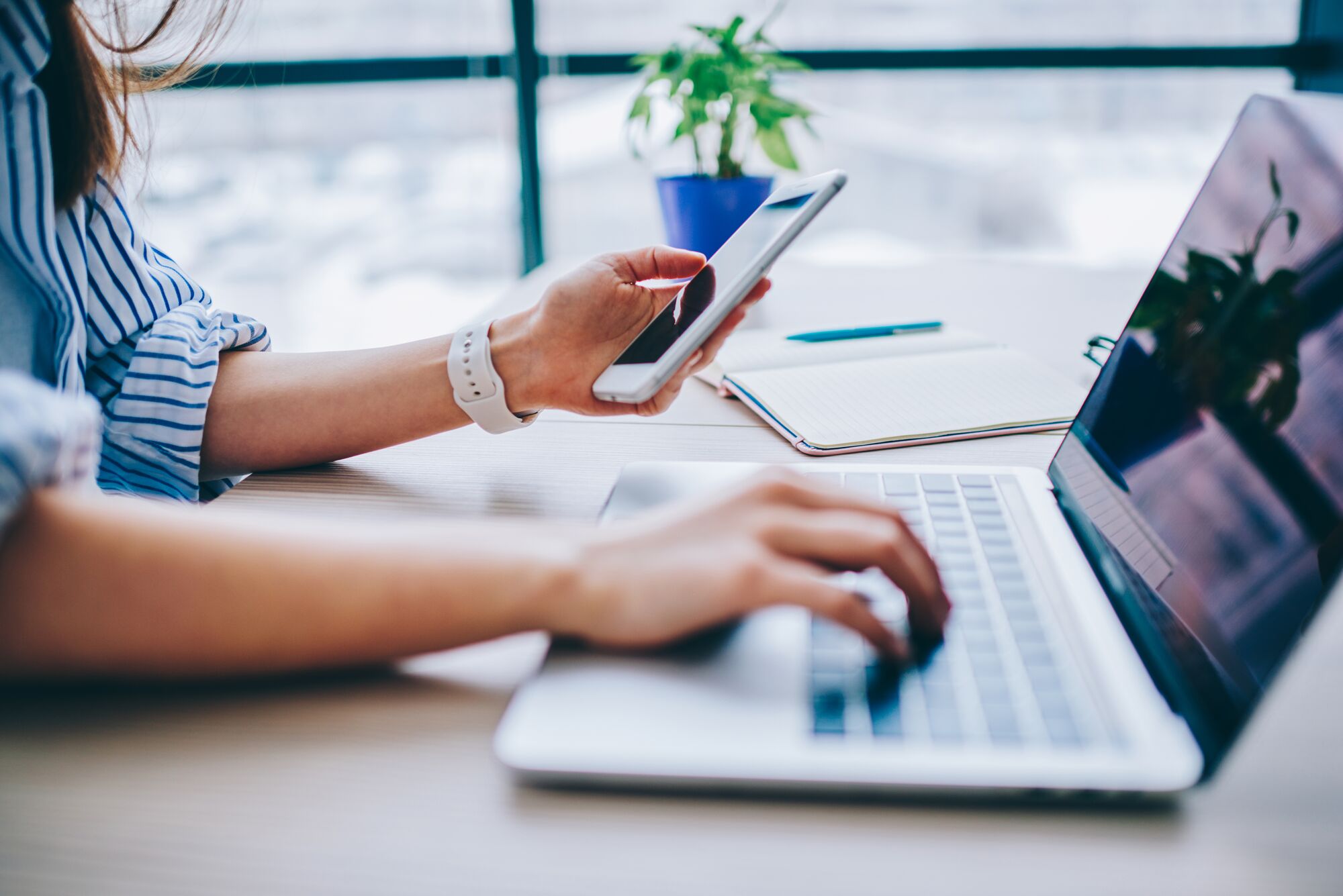Businesswoman using her laptop and phone